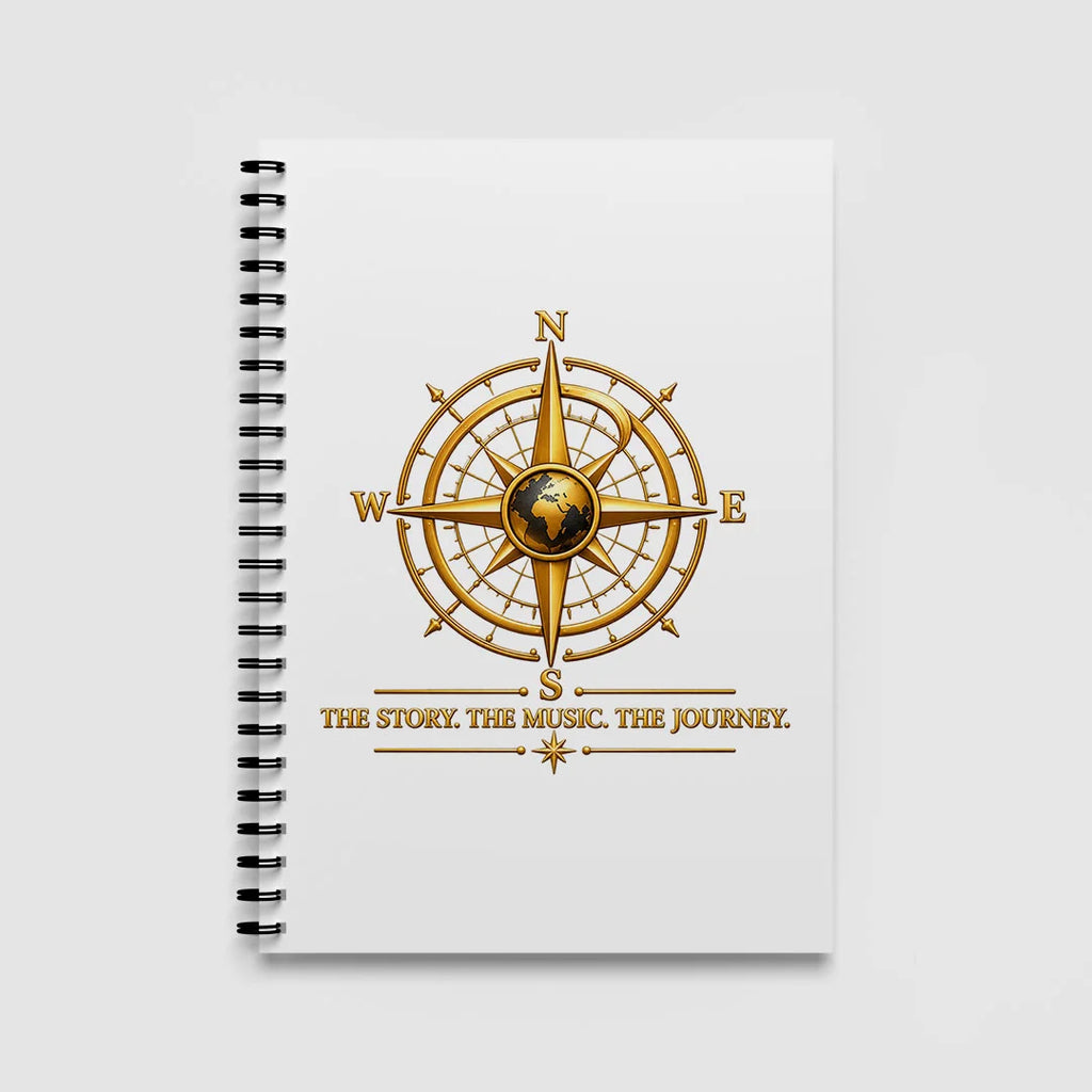 White A5 spiral notebook with a gold globe compass and THE STORY. THE MUSIC. THE JOURNEY. tagline on the front cover.