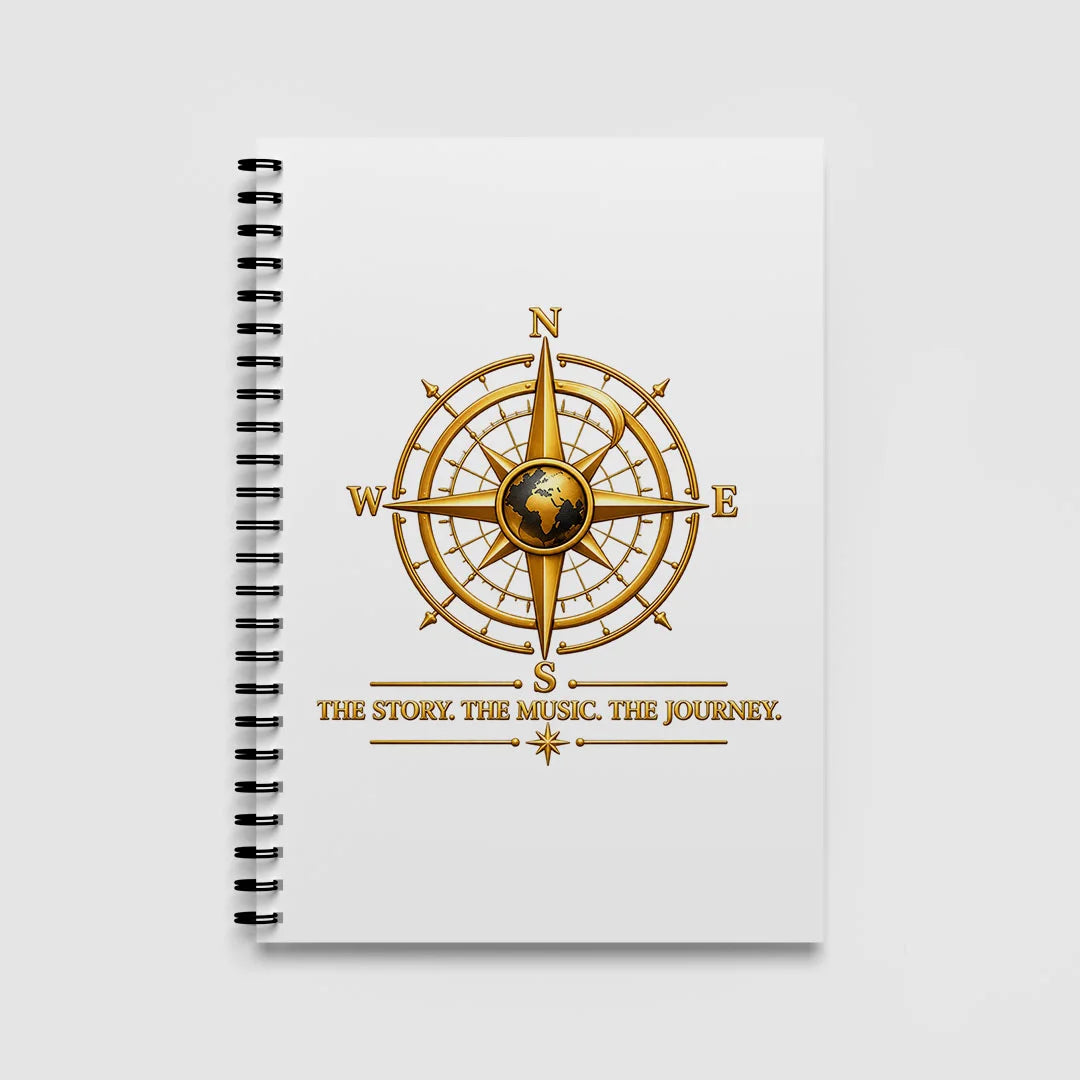 White A5 spiral notebook with a gold globe compass and THE STORY. THE MUSIC. THE JOURNEY. tagline on the front cover.